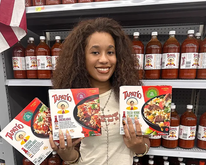 A college student Brand Advocate showcasing consumer food products in a retail setting for an EvolveZ campus program